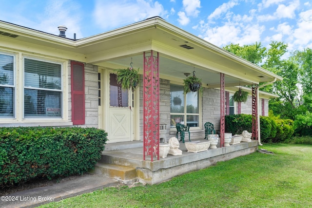 property entrance with a porch and a yard