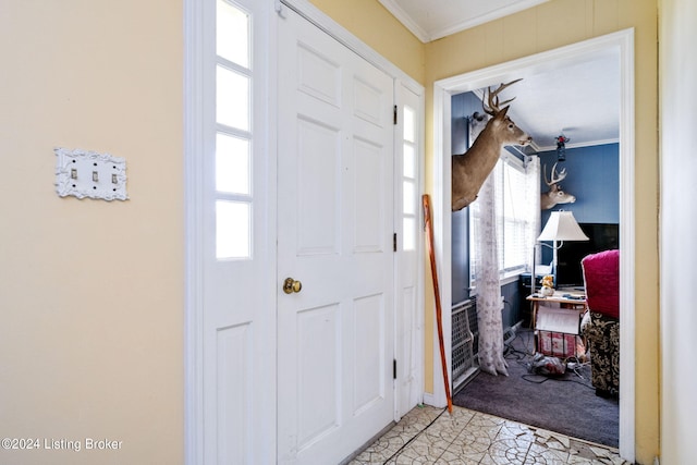 entryway featuring light tile patterned floors and ornamental molding