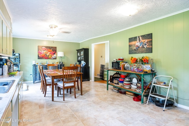 dining space featuring ornamental molding, sink, a textured ceiling, and ceiling fan