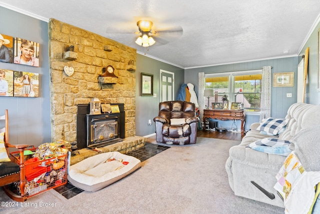 carpeted living room with crown molding, a stone fireplace, and a textured ceiling