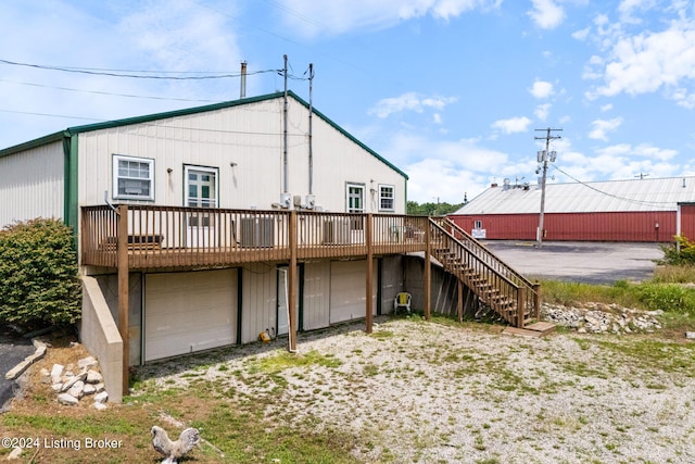 back of property featuring a wooden deck and a garage