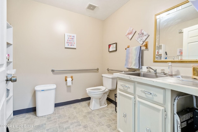 bathroom featuring vanity, toilet, and a textured ceiling