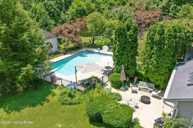 view of swimming pool with a patio area, a lawn, and an outdoor living space with a fire pit