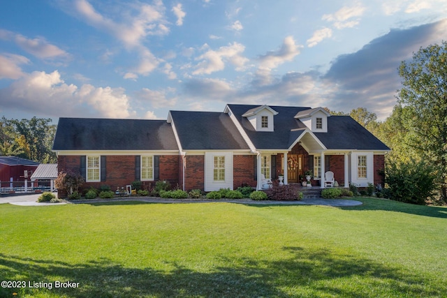 cape cod home featuring a front lawn