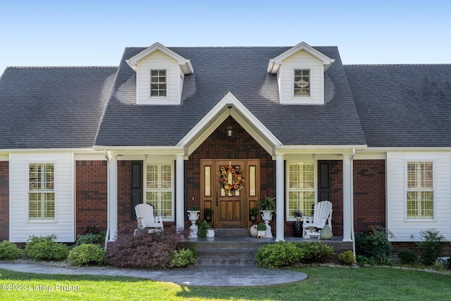 cape cod-style house featuring covered porch