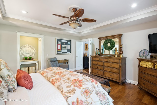 bedroom with dark hardwood / wood-style flooring, a tray ceiling, crown molding, and ceiling fan