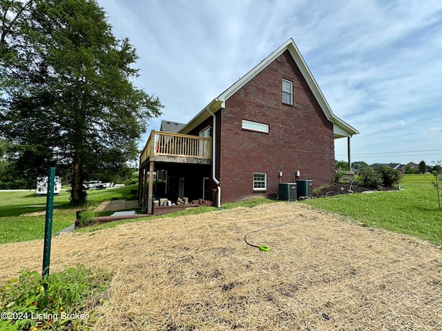 view of side of home featuring a yard and central AC