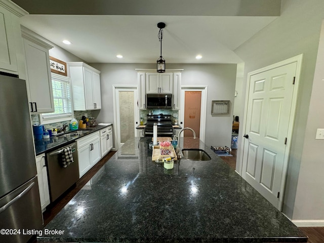 kitchen with white cabinets, appliances with stainless steel finishes, decorative backsplash, pendant lighting, and sink