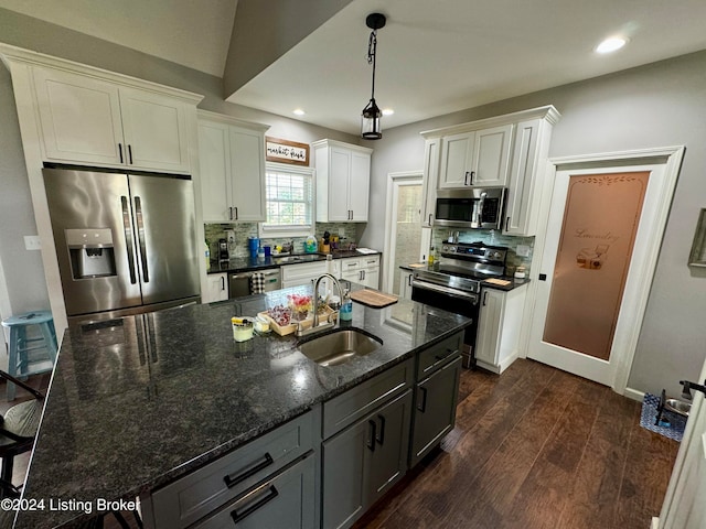 kitchen featuring white cabinetry, stainless steel appliances, sink, backsplash, and dark wood-type flooring