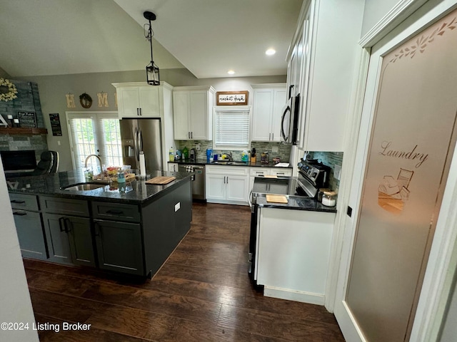 kitchen featuring white cabinetry, dark hardwood / wood-style flooring, sink, a center island with sink, and appliances with stainless steel finishes