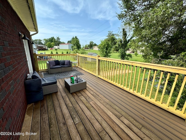 wooden terrace featuring an outdoor living space and a yard