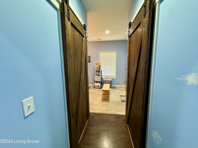 hallway with dark hardwood / wood-style flooring and a barn door