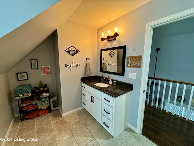 bathroom with vanity, hardwood / wood-style flooring, and vaulted ceiling