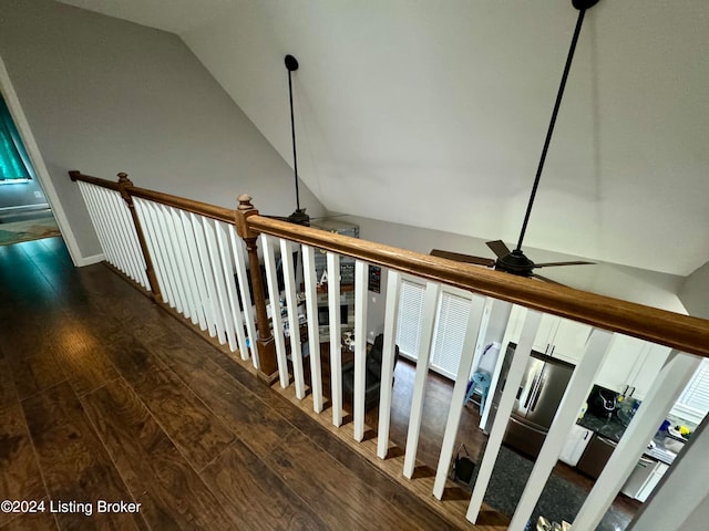 stairs with vaulted ceiling, ceiling fan, and hardwood / wood-style floors