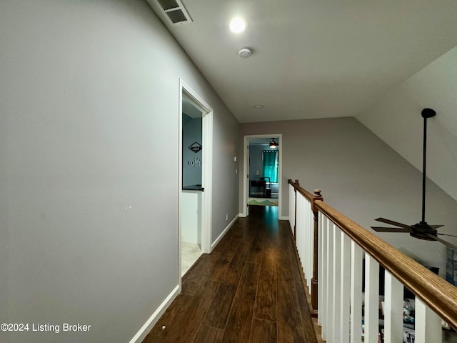 hallway with wood-type flooring and vaulted ceiling