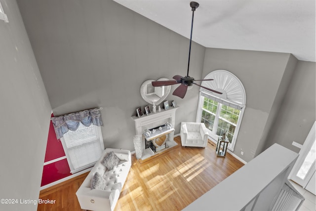 living room featuring hardwood / wood-style floors, high vaulted ceiling, and ceiling fan