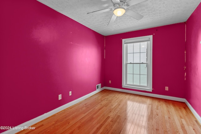 unfurnished room featuring ceiling fan, light hardwood / wood-style flooring, and a textured ceiling