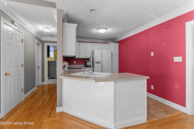 kitchen featuring a textured ceiling, white fridge with ice dispenser, white cabinets, and light wood-type flooring