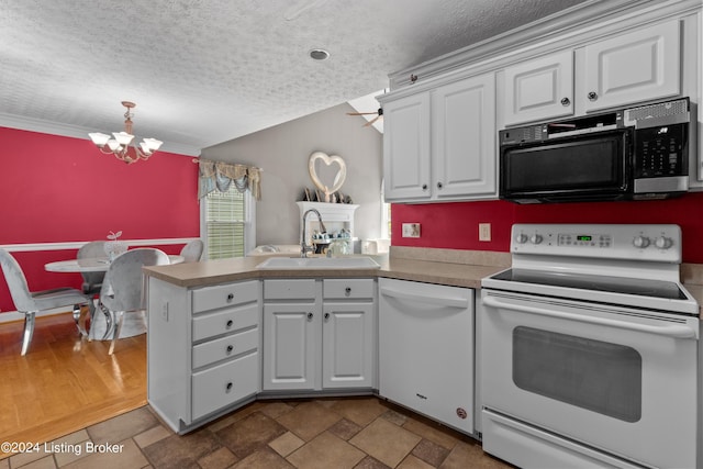 kitchen with white appliances, kitchen peninsula, sink, and white cabinets