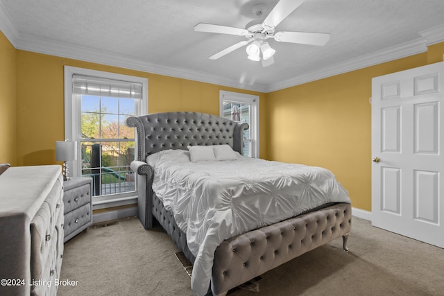 carpeted bedroom with a textured ceiling, ornamental molding, and ceiling fan