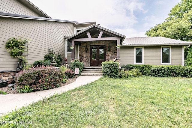 doorway to property featuring a yard and french doors