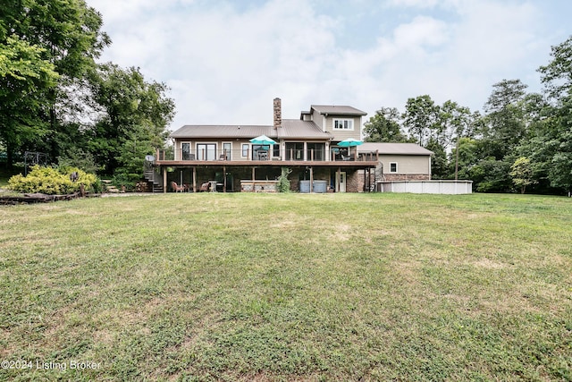 back of property with a wooden deck and a yard