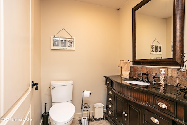 bathroom featuring vanity, backsplash, and toilet