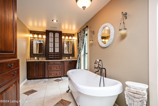 bathroom with a washtub, vanity, and tile patterned floors