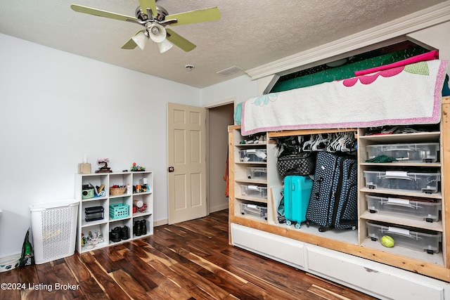 bedroom with dark wood-type flooring, a textured ceiling, and ceiling fan