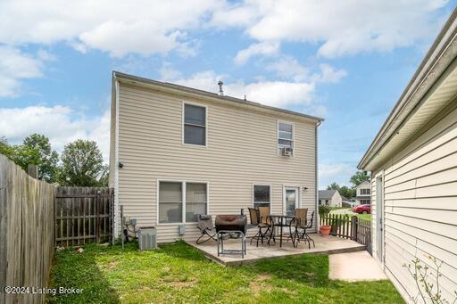 back of property featuring a patio, central AC unit, and a lawn