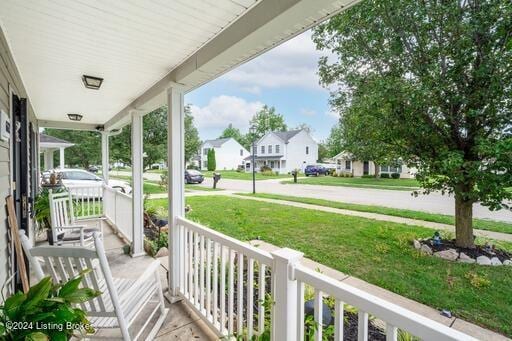 wooden deck with a porch and a yard