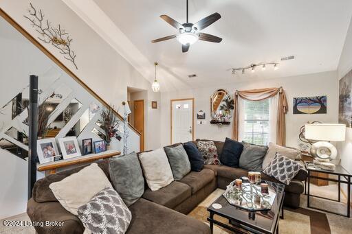 living room featuring ceiling fan, rail lighting, and lofted ceiling with beams