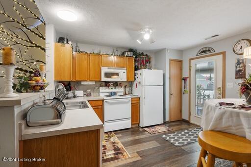 kitchen featuring dark hardwood / wood-style flooring, sink, and white appliances