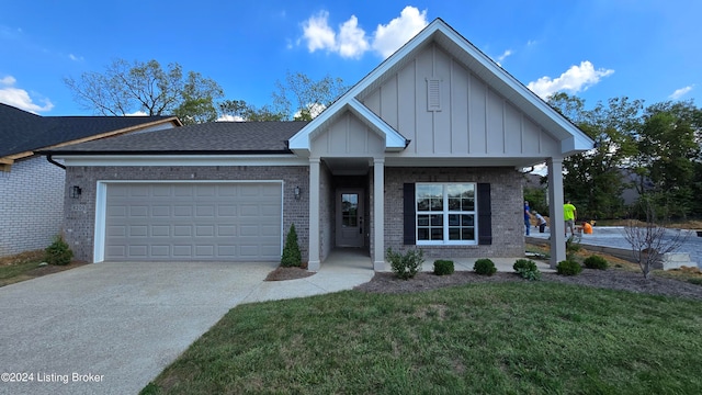 view of front of home with a garage, a front yard, and covered porch