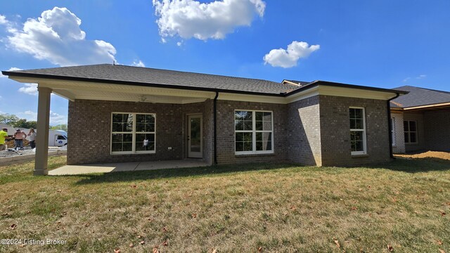 back of property featuring a patio area and a lawn