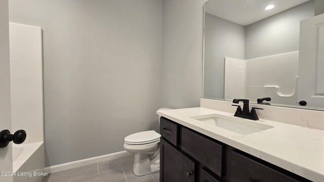 full bathroom featuring tile patterned floors, toilet, vanity, and  shower combination