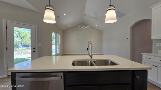 kitchen featuring lofted ceiling, pendant lighting, dishwasher, and sink