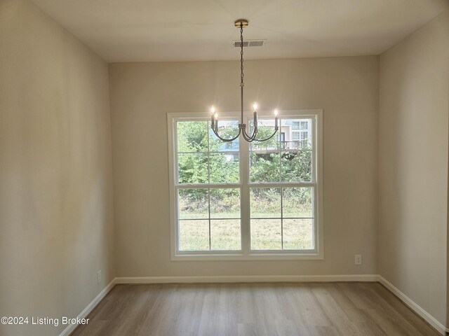 interior space with light wood-type flooring, a notable chandelier, and plenty of natural light