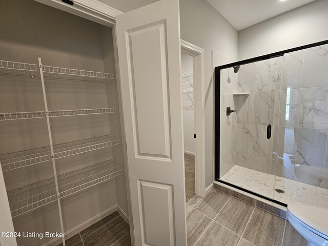 bathroom with toilet and an enclosed shower