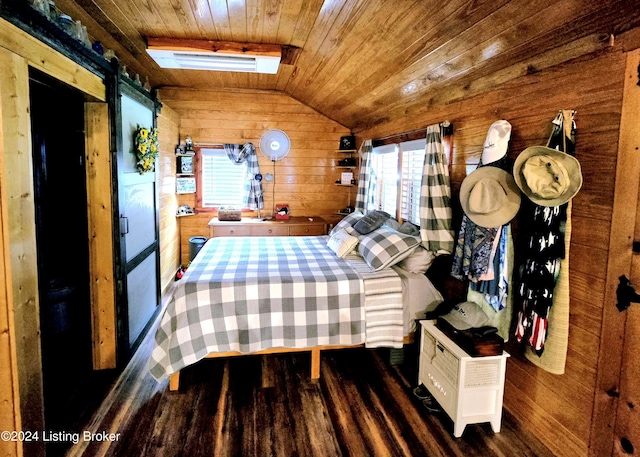 unfurnished bedroom with a barn door, wooden walls, visible vents, wood ceiling, and vaulted ceiling