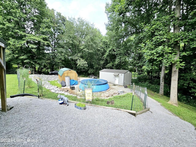 view of jungle gym with fence, a storage unit, and an outbuilding