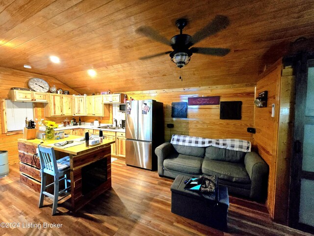 kitchen featuring lofted ceiling, wooden walls, wood finished floors, wood ceiling, and freestanding refrigerator