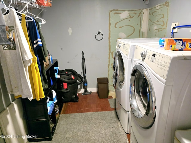 washroom with laundry area, washing machine and clothes dryer, and wood finished floors