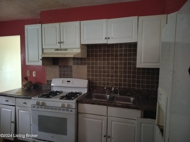 kitchen featuring sink, white cabinets, decorative backsplash, white gas stove, and a textured ceiling