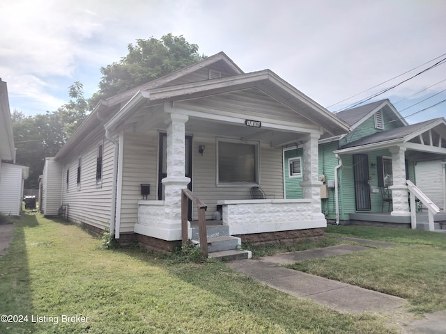 bungalow-style house with a porch and a front lawn