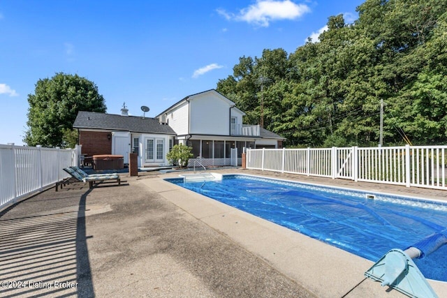 view of swimming pool featuring a patio area and a hot tub