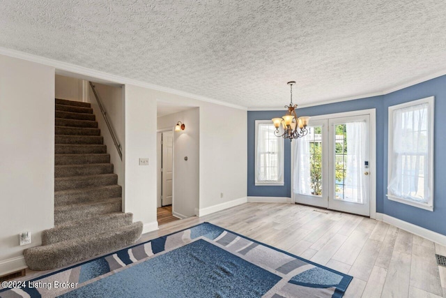 interior space with crown molding, an inviting chandelier, a textured ceiling, and light hardwood / wood-style floors