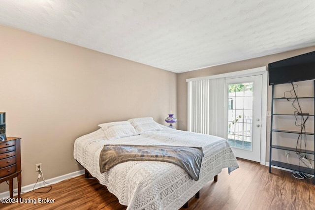 bedroom featuring access to exterior and dark hardwood / wood-style floors