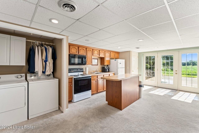 kitchen with washer and dryer, white appliances, light colored carpet, a drop ceiling, and sink