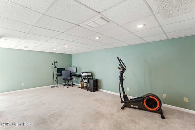 workout area featuring light carpet and a paneled ceiling